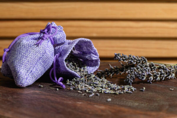 Aroma sachet with lavender flowers on a wooden background. close up.