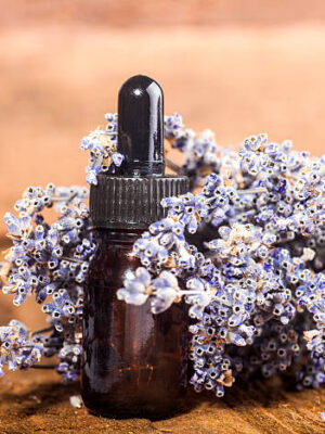 Spa background with bunch of lavender and glass vial with essential oil.